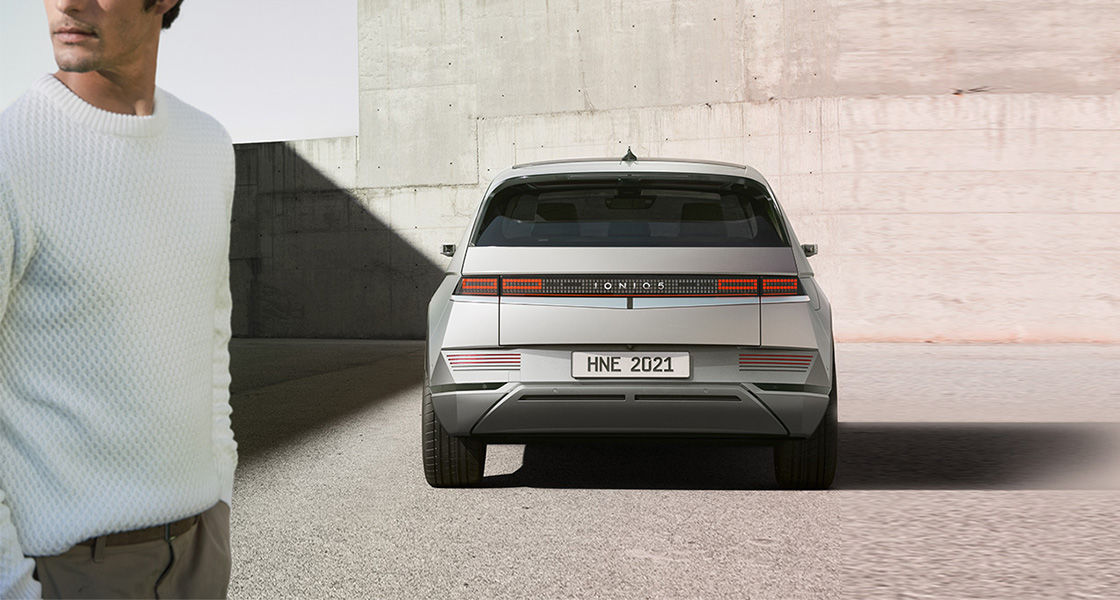 Side-front view of orange Grandi10 with lakeside view at night